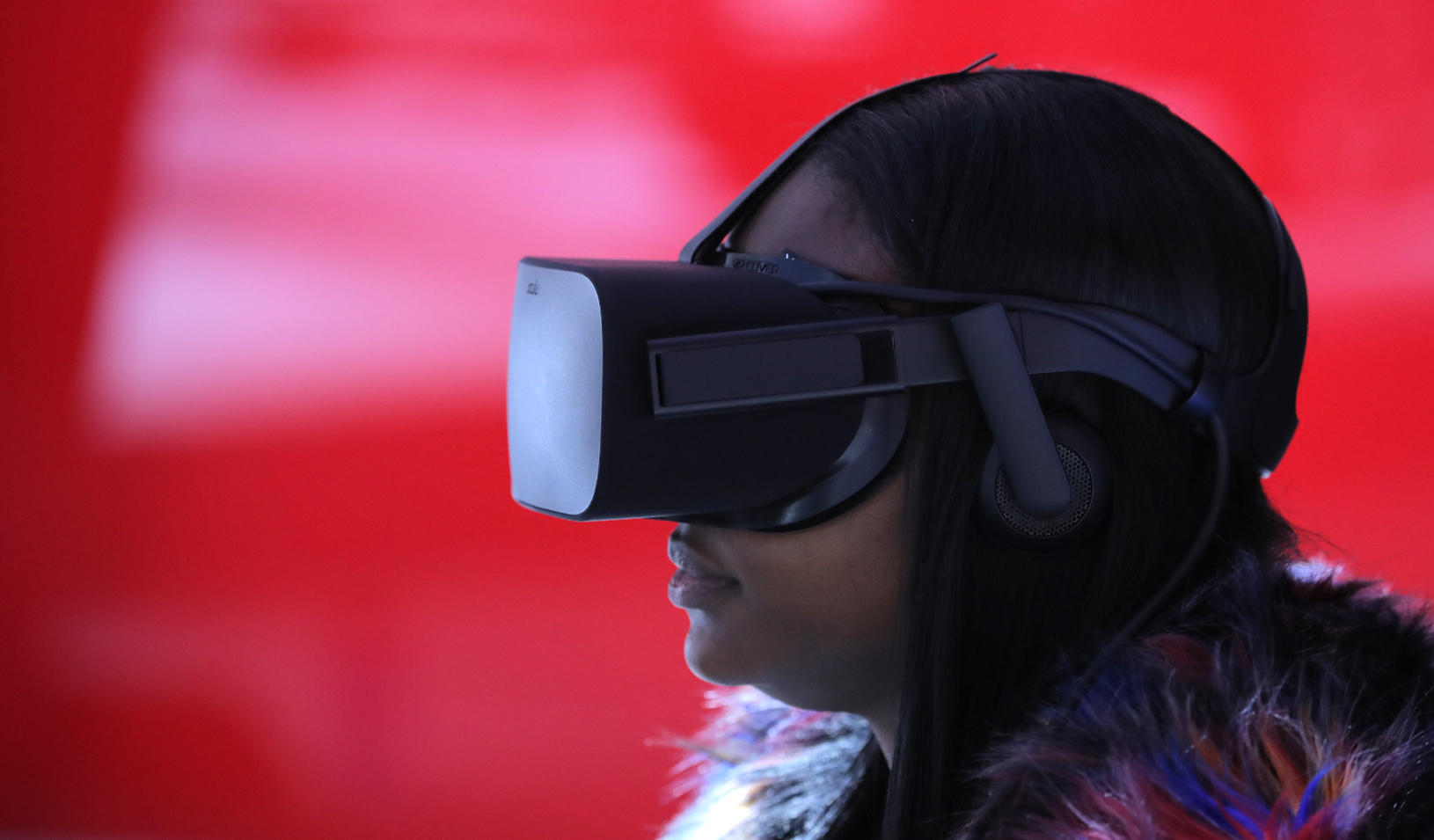 A woman wears VR goggles as she sits in a virtual reality booth. Credit: Reuters/Brendan McDermid