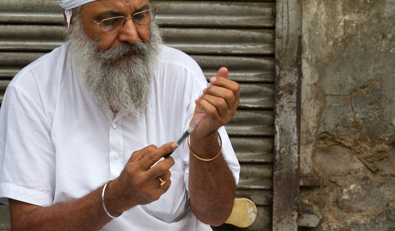 An Indian medical volunteer works at a roadside clinic in Old Delhi treating the homeless. Credit: iStock/BDphoto