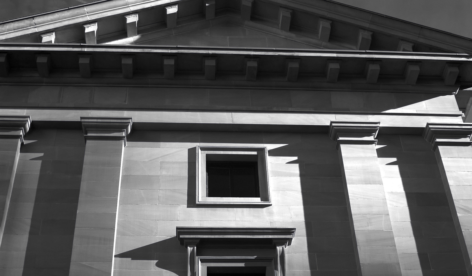 Black and white photo of a bank from below, in deep shadow and looking foreboding. iStock/RSeanGalloway