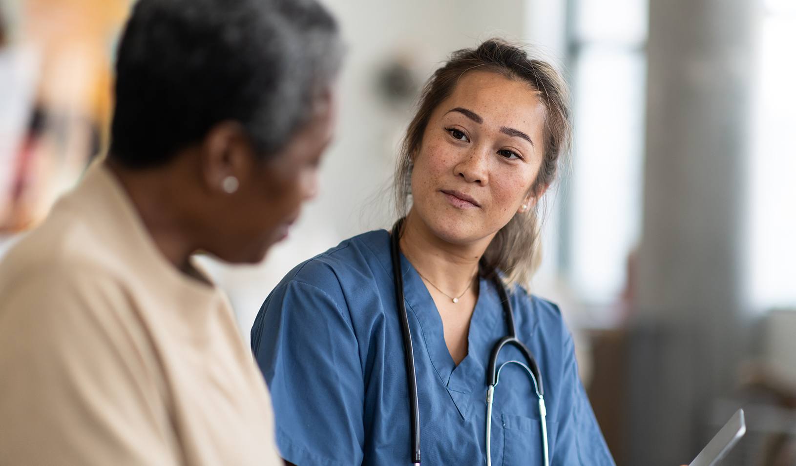 A doctor speaks with her elderly patient. Credit: iStock/FatCamera