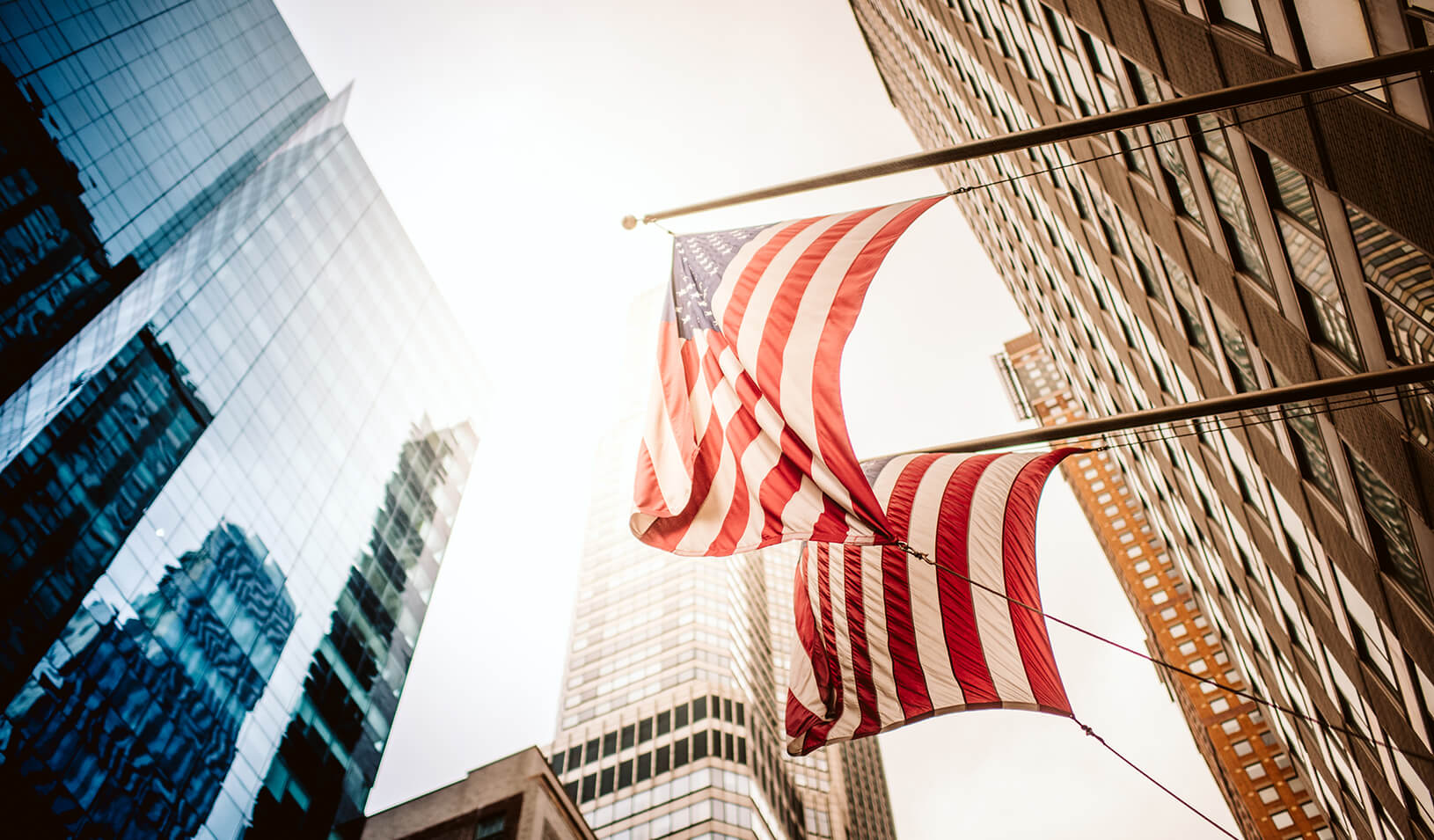 New York City office skyscraper with US Flags Reflection in the sunlight. Credit: iStock/PPAMPicture