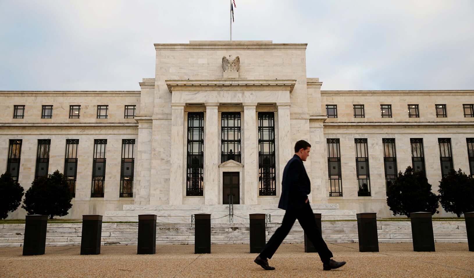 A man walks past the Federal Reserve Bank in Washington, D.C. | Reuters/Kevin Lamarque