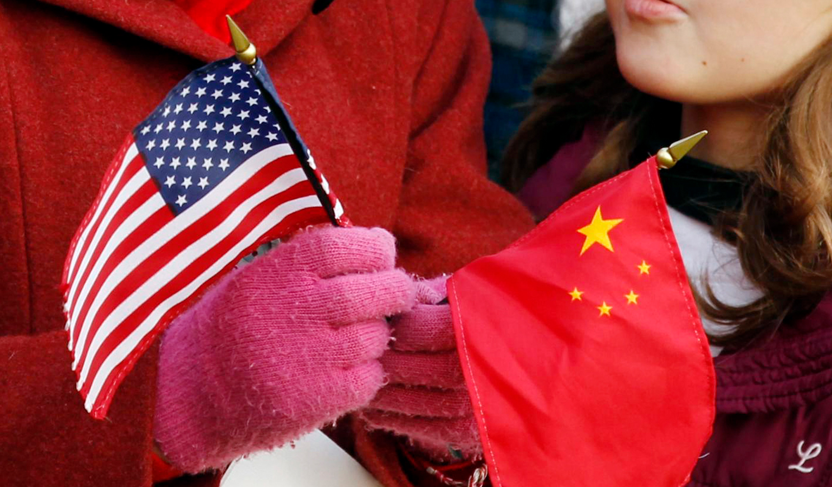 A girl holds a U.S. and Chinese flag. Credit: Reuters/Kevin Lamarque