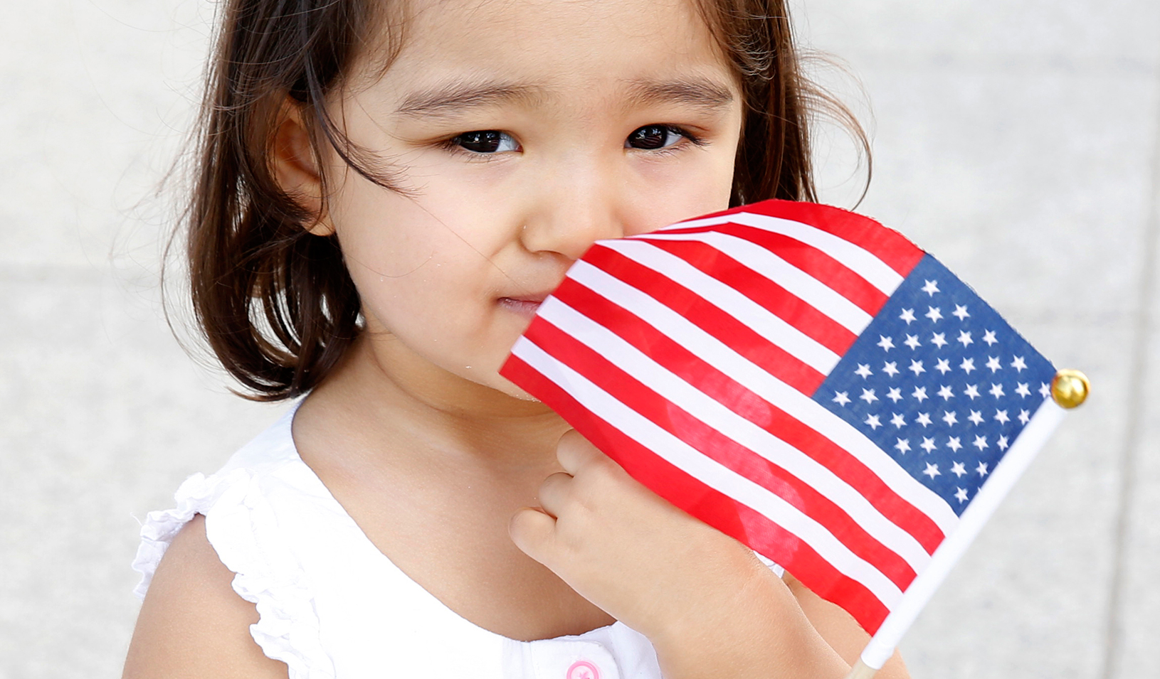 Little girl holding an American flag. | Reuters/Kevin Lamarque