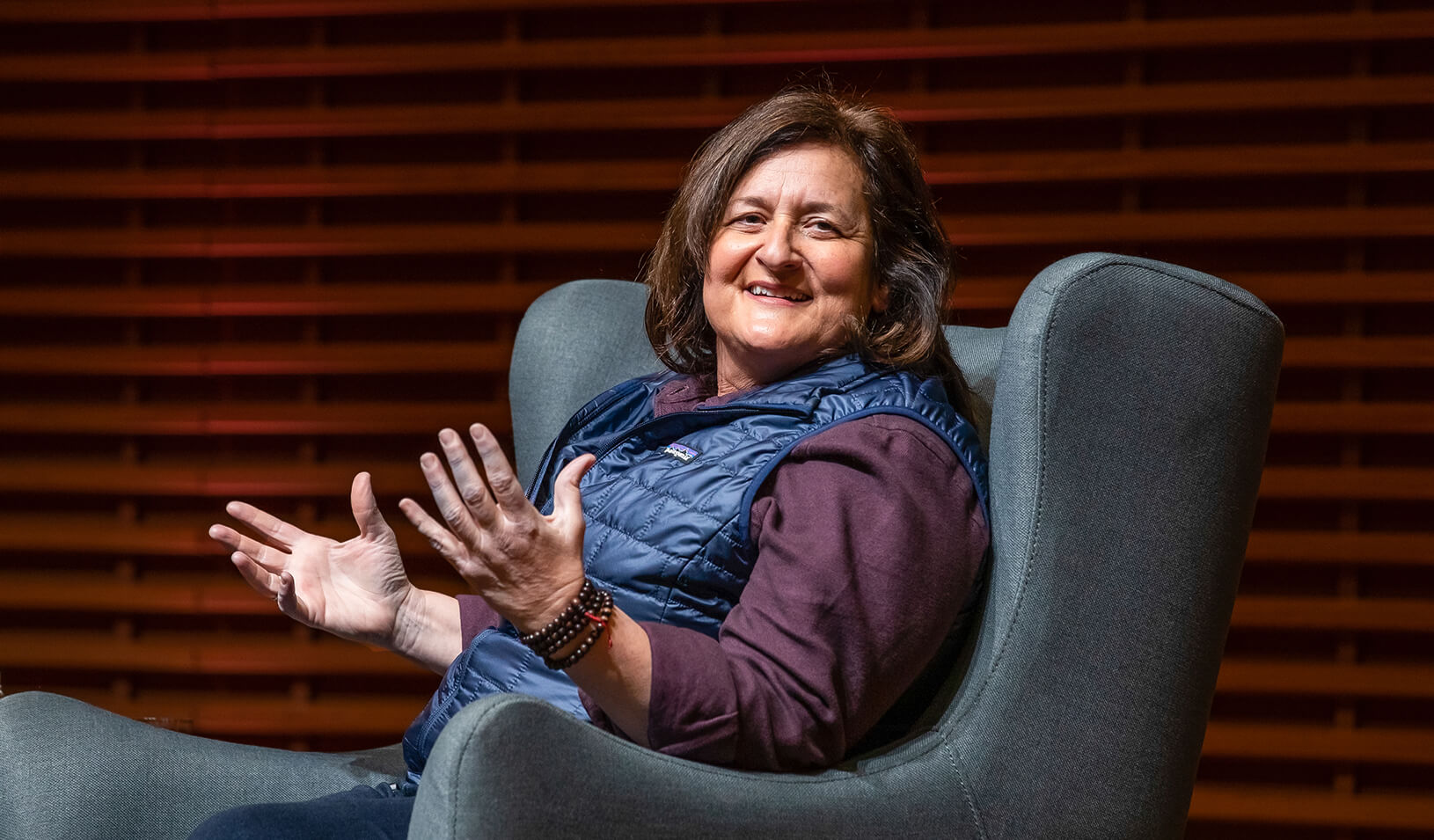 Close up shot of Rose Marcario sitting and turned toward the camera, smiling and holding up her hands. Credit: Stacy Geiken