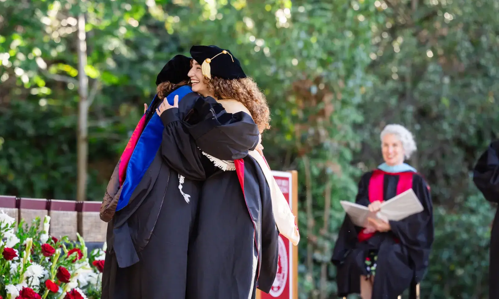 Student and professor hugging on stage at GSB 2026 Graduation 