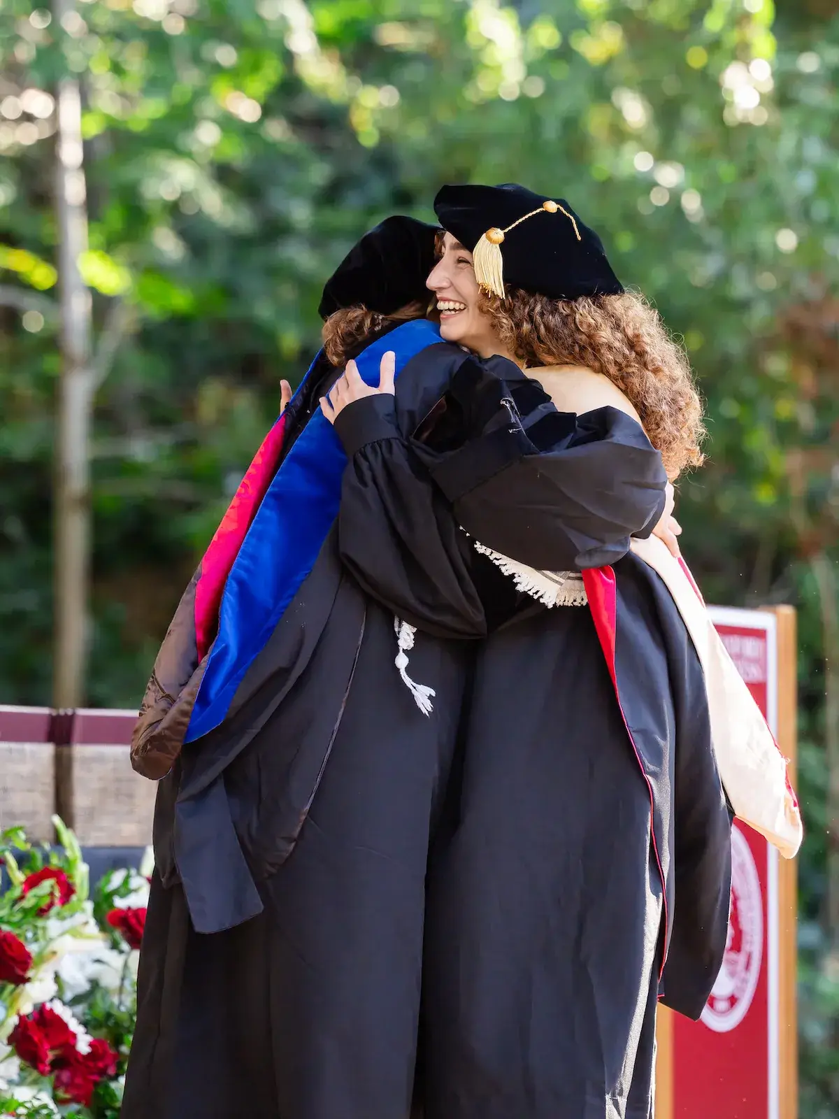 Student and professor hugging on stage at GSB 2026 Graduation 