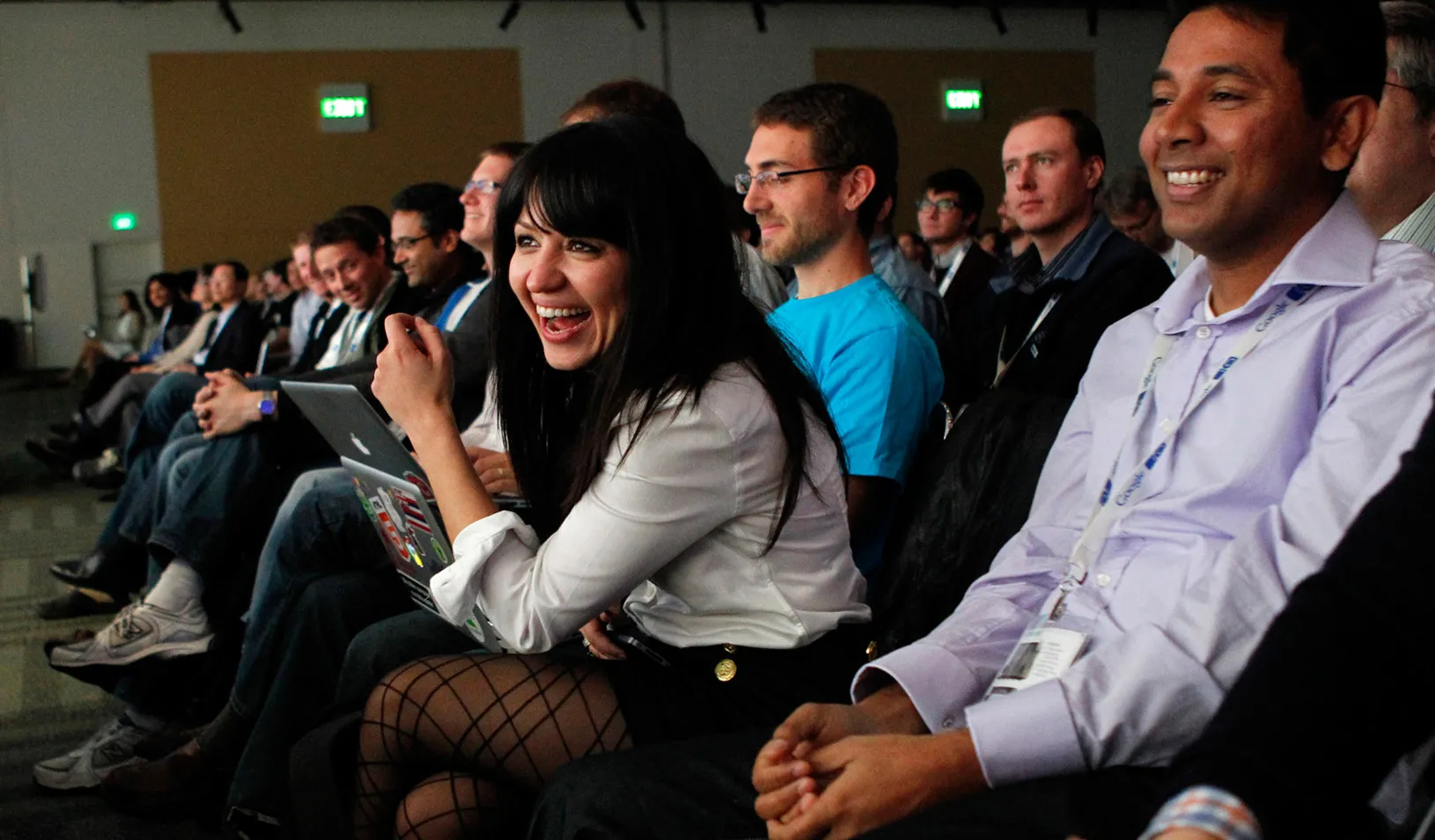 Woman leaning forward and laughing while listening to a presentation