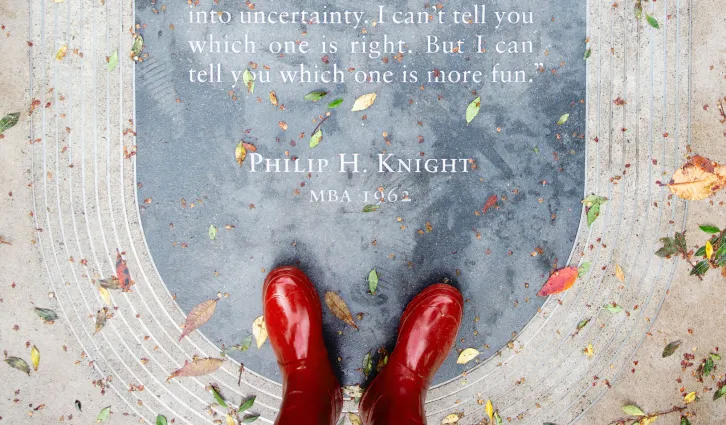 A shot from above looking down at red boots on the Phil Knight Plaque in Town Square. Credit: Toni Bird