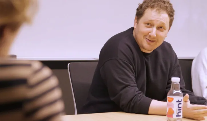 Stanford GSB alumni David Rogier sitting at a conference table during a meeting. Credit: Video by Todd Holland