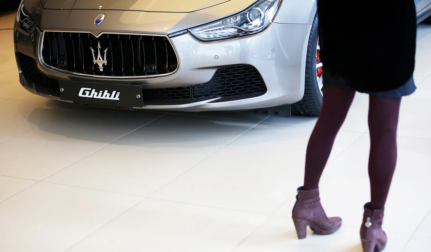 A woman looks at a Maserati Ghibli car at its dealership. | Reuters/Kim 