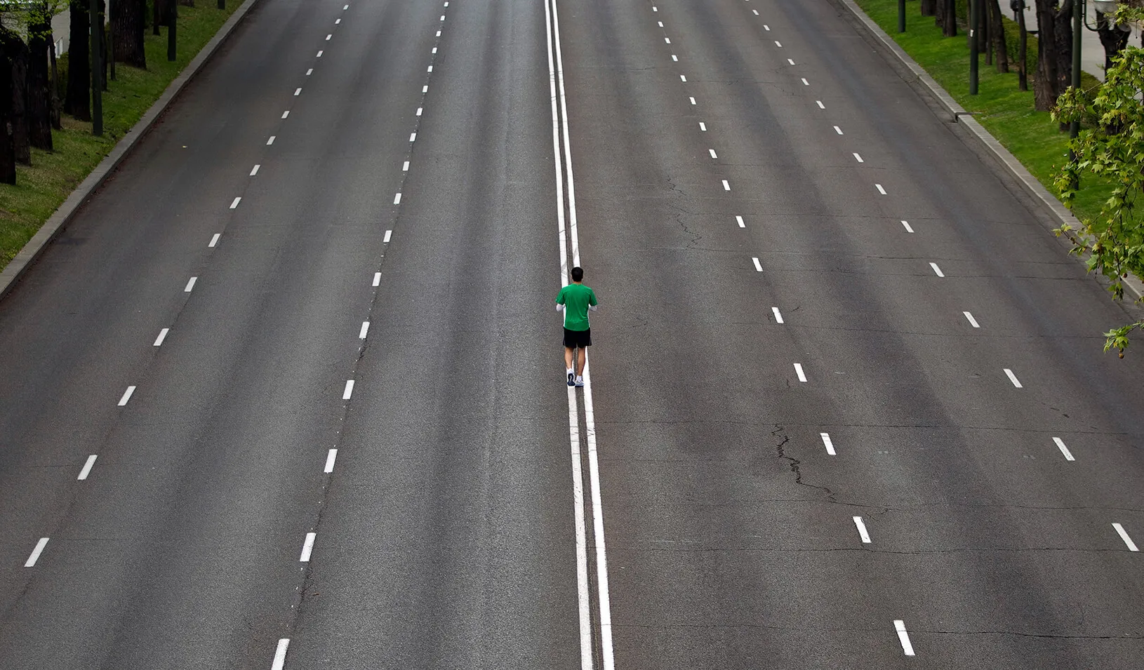 A man standing in the middle of an empty six-lane road | Reuters/Paul Hanna 