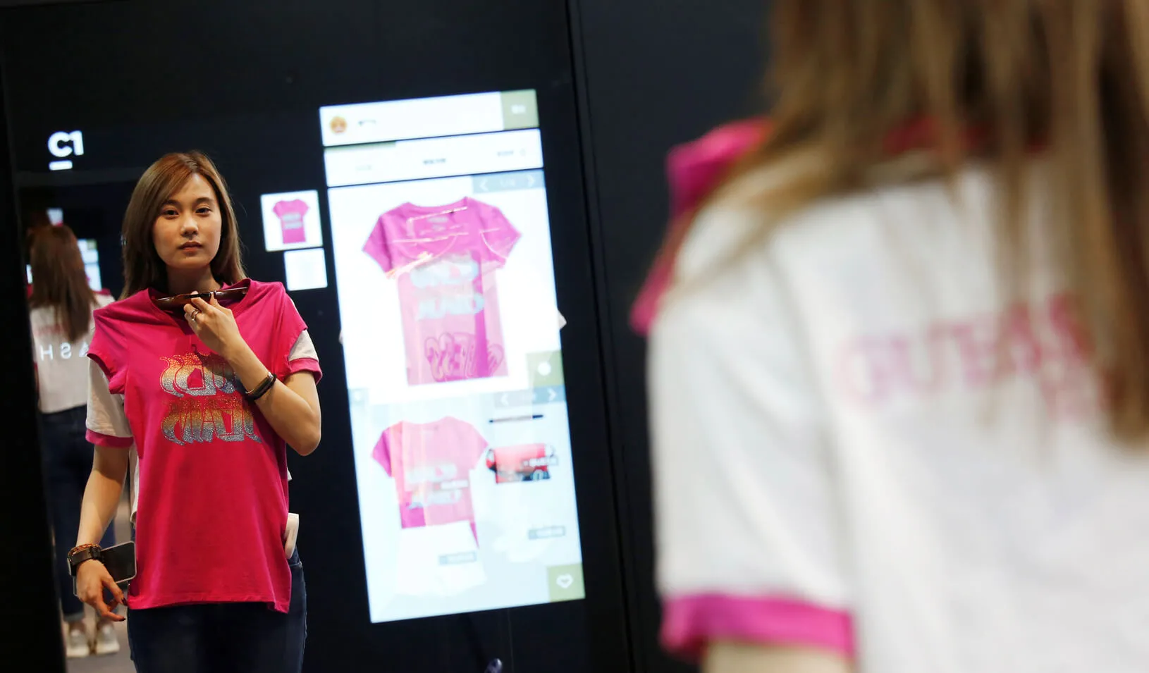 A model demonstrates Alibaba’s FashionAI technology, with the chosen item’s details being displayed on the mirror, at a pop-up store in partnership with fashion brand GUESS, on the sidelines of the Artificial Intelligence on Fashion and Textile Conference at the Hong Kong Polytechnic University in Hong Kong, China July 3, 2018. Credit: Reuters/Bobby Yip