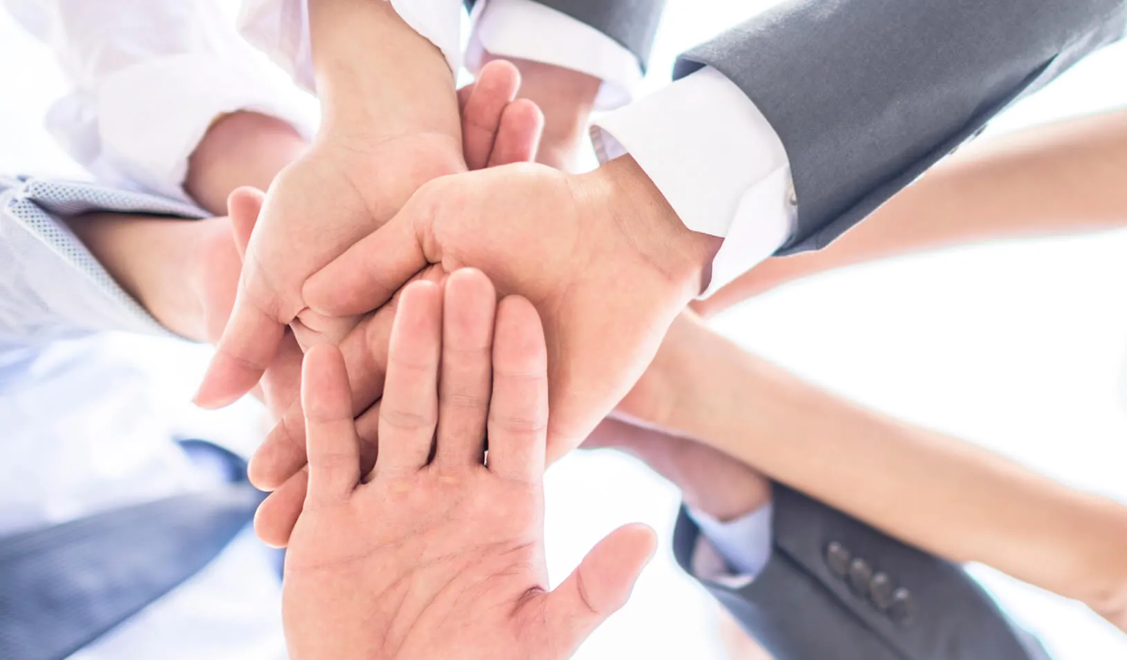 Six hands are clasped in friendship - all white | iStock/andresr