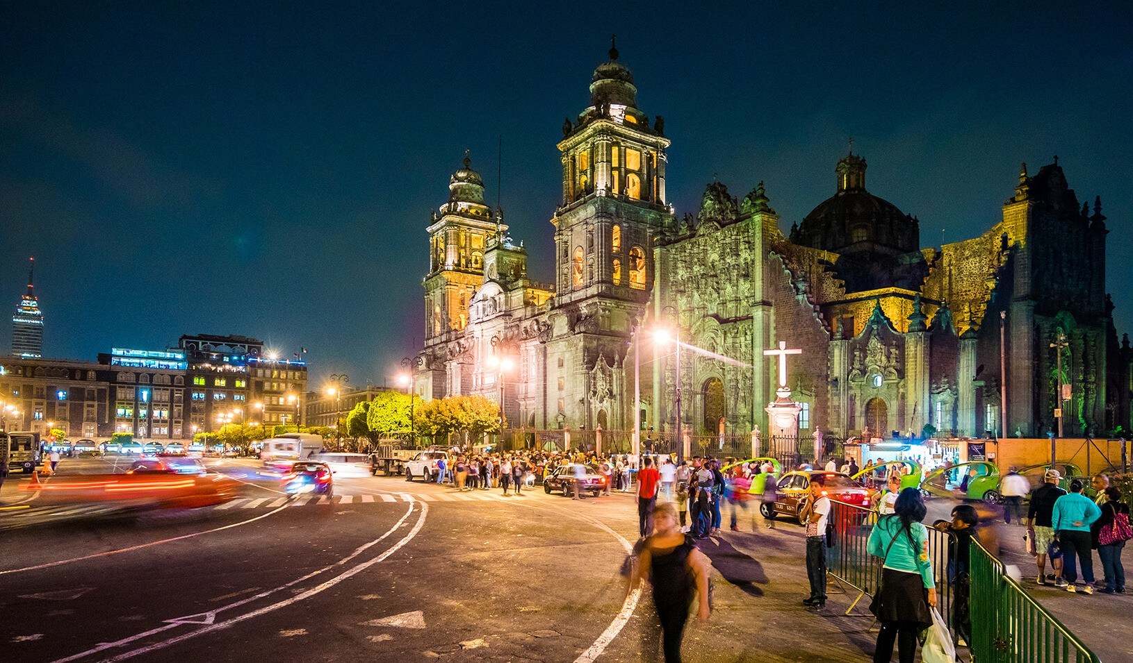View of the busy street outside the Metropolitan Cathedral of the Assumption in Mexico City, Mexico at night. | iStock/Holgs